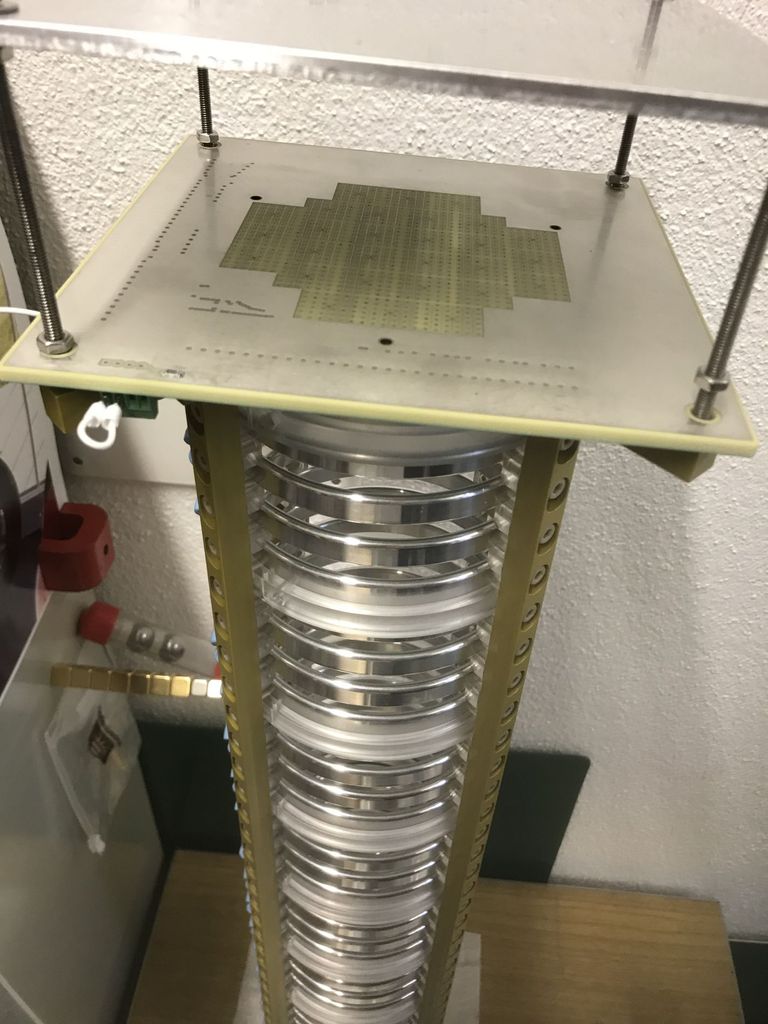 This shows a prototype pixelated charge readout monted to a small Liquid Argon Time Projection Chambre. The Time Projection Chamber is cylindrical; 0.6 m long with a 0.1 m internal diameter. The polished aluminium rings are used to shape the electric field, guiding the drifting electrons to the charge readout. The Time projection chambers in the DUNE near detector will be rectangular cuboids; 3.0 m tall, 1.0 m long and 0.5 m wide. In DUNE, drift direction is the width, 0.1 m shorter than the pictured prototype. This shows a prototype pixelated charge readout monted to a small Liquid Argon Time Projection Chambre. The Time Projection Chamber is cylindrical; 0.6 m long with a 0.1 m internal diameter. The polished aluminium rings are used to shape the electric field, guiding the drifting electrons to the charge readout. The Time projection chambers in the DUNE near detector will be rectangular cuboids; 3.0 m tall, 1.0 m long and 0.5 m wide. In DUNE, drift direction is the width, 0.1 m shorter than the pictured prototype.