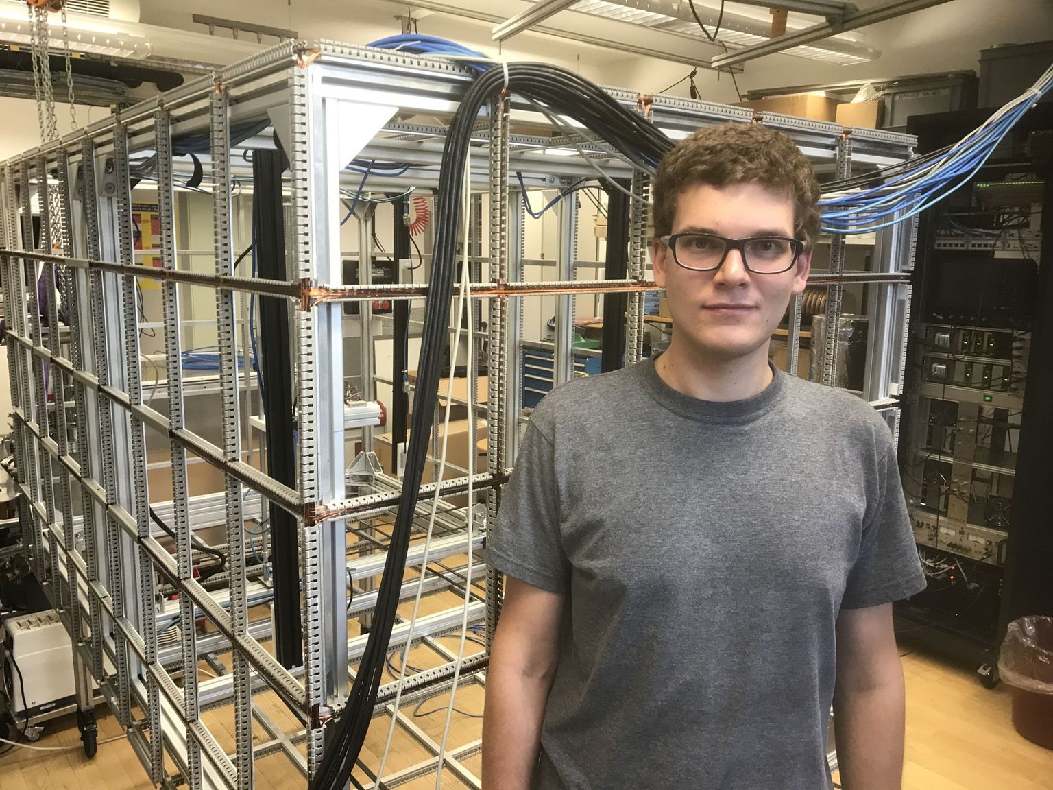 ETH graduate student Michal Rawlik with the small ‘prototype cage’, which serves to neutralize the magnetic fields in its interior.