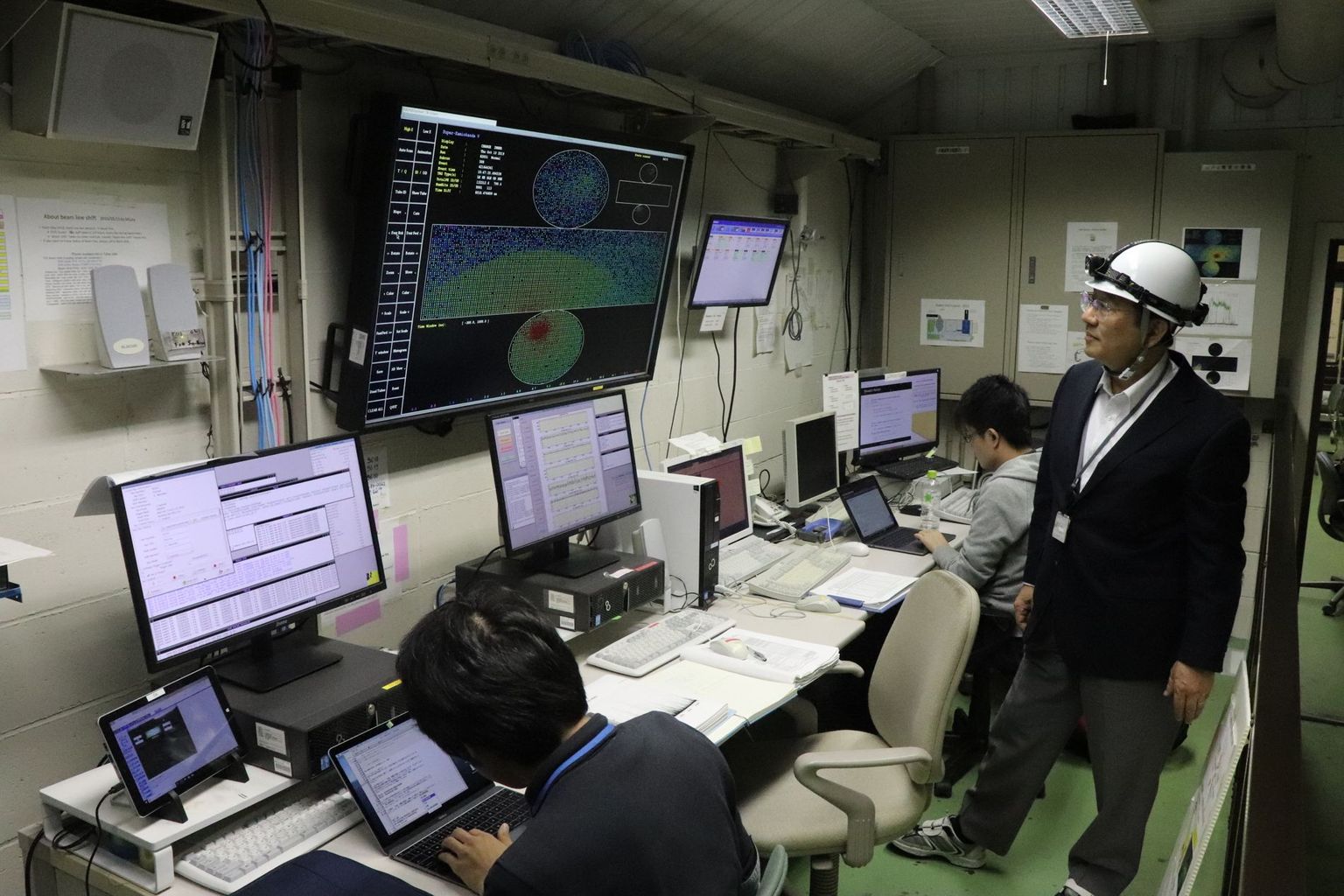 In the control room of the Super-Kamiokande. The large screen shows a current cosmic-ray event. Photo: B. Vogel