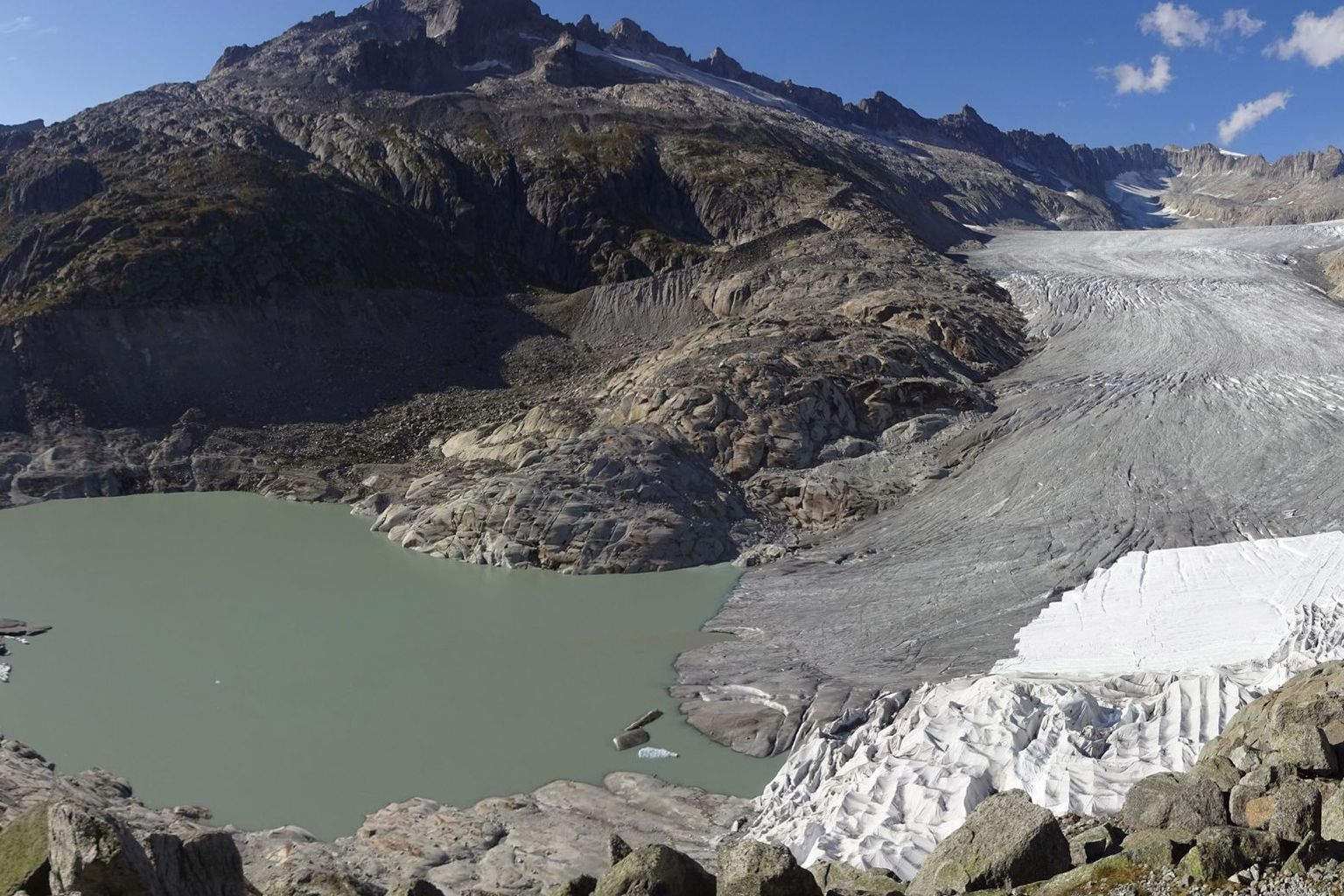 Le lac se trouvant à la langue du glacier du Rhône (VS) s'est de nouveau fortement développé en 2018. On tente de préserver la grotte glaciaire en recouvrant la glace de la toison blanche.