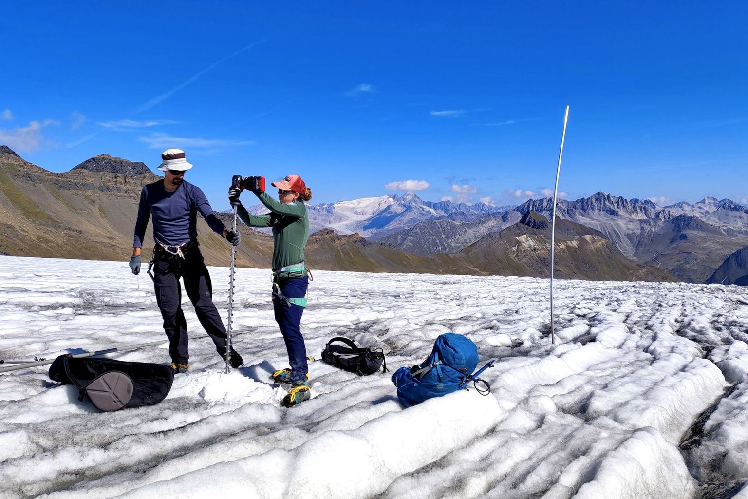Nachbohren einer Messstange auf dem Griesgletscher (VS). Ein Netzwerk von Pegeln wie rechts im Bild erlaubt die Bestimmung des Verlustes auf der ganzen Gletscherfläche.