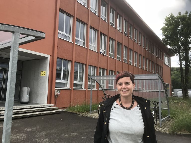 Lea Caminada in front of the PSI building, where she works as a particle physicist.