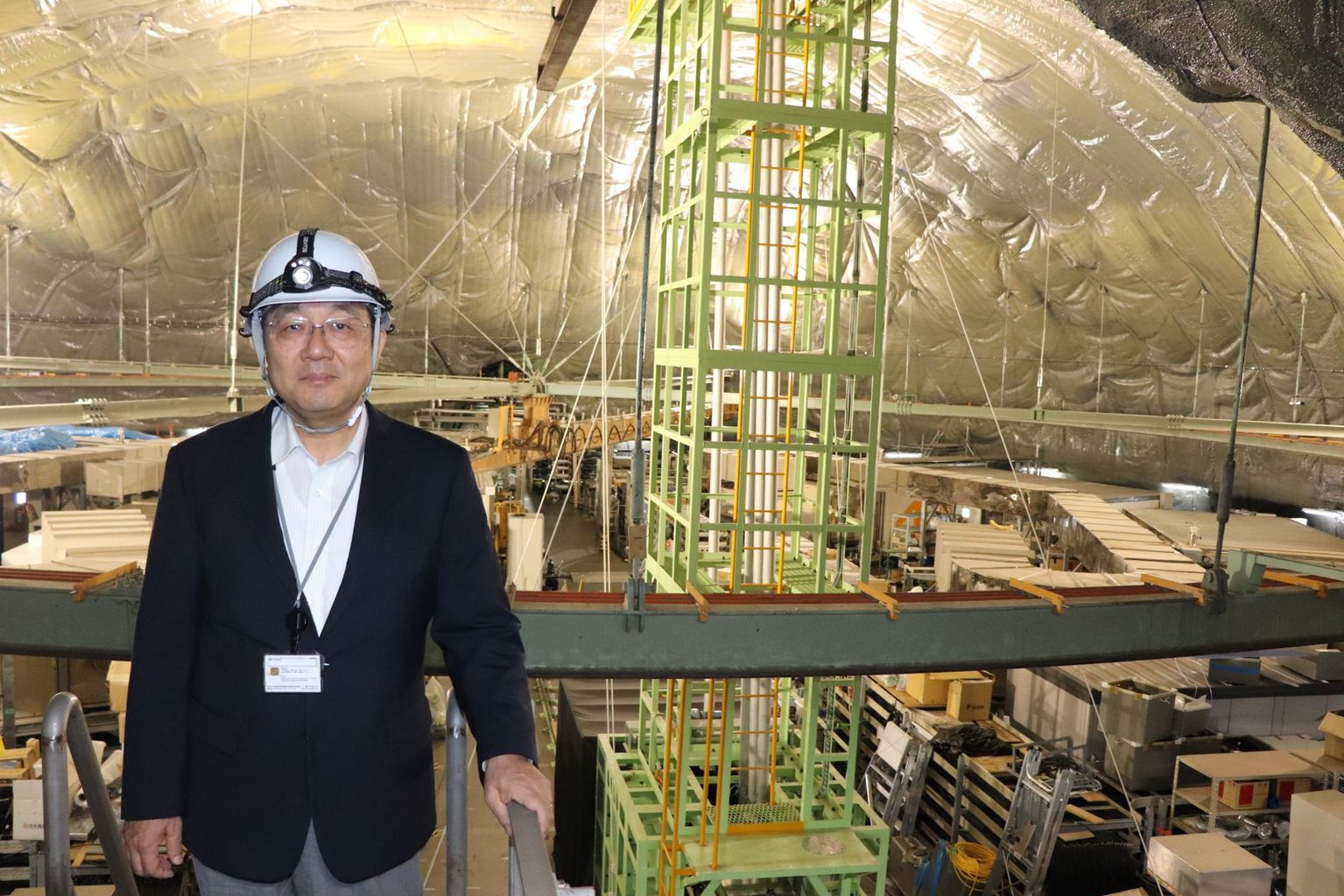 Prof. Nakahata in the rock cavern 1000 meters below ground. Directly below is the huge water tank with which the Super-Kamiokande detects neutrinos. Photo: B. Vogel