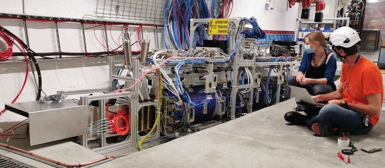 Zwei Mitarbeitende von der Uni Genf testen elektronische Karten des Teilchendetektors FASER während der Inbetriebnahmephase des Experiments im Jahr 2021