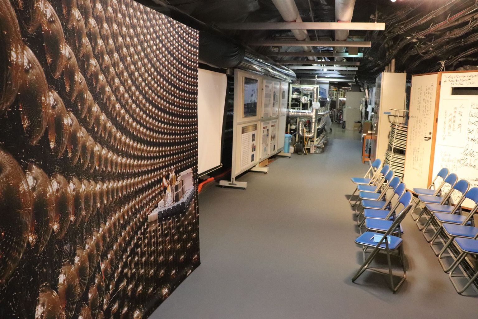 The visitor's area next to the Super-Kamiokande. The detector itself cannot be visited, as it is filled with water. The photo on the left was taken during inspection work: It shows the photo sensors (Photomultiplier Tubes / PMT) with which the inner wall of the detector is lined. Each PMT has a diameter of 50 cm. Photo: B. Vogel